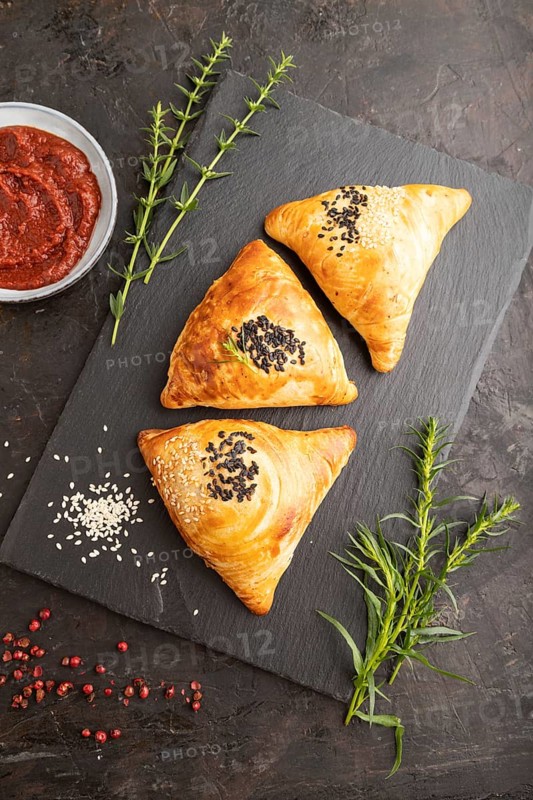 Homemade asian pastry samosa on black concrete background. top view, flat lay, close up