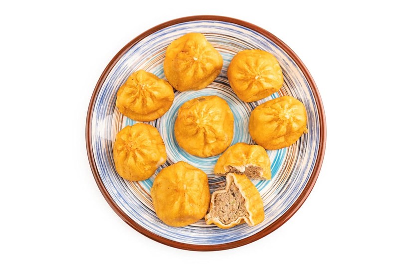 Fried manti dumplings isolated on white background. Top view, flat lay, close up