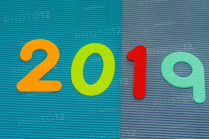 The numbers 2019 made of felt of different colors photographed on blue and maroon corrugated background