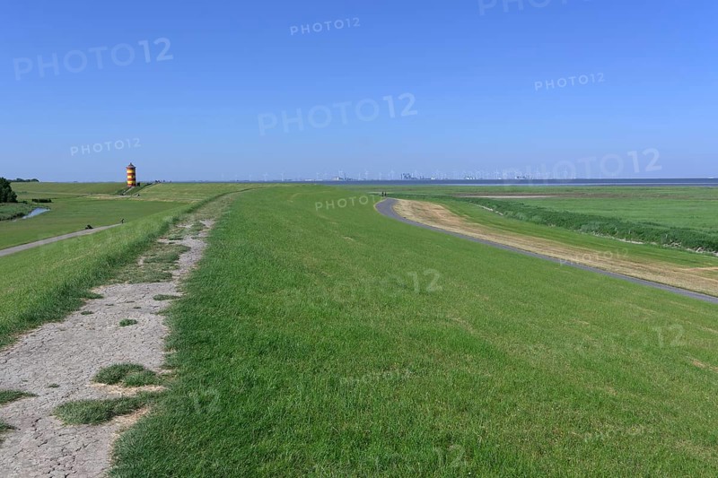 Dyke with Pilsum lighthouse and view of Eemshaven, Krummhoern, Germany, Europe