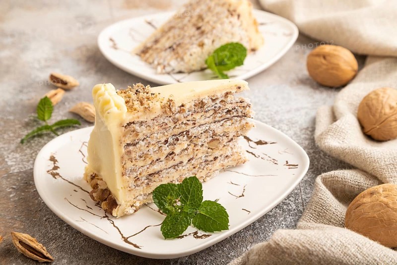 Walnut and almond cake on brown concrete background and linen textile. side view, close up
