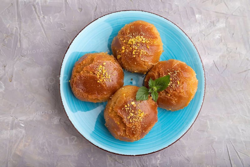 Homemade traditional turkish dessert sekerpare with almonds and honey on gray concrete background. top view, flat lay, close up