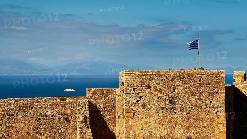 Historic fortress walls under a partly cloudy sky with Greek flag and sea view, Chlemoutsi, High Medieval Crusader Castle, Kyllini Peninsula, Peloponnese, Greece, Europe
