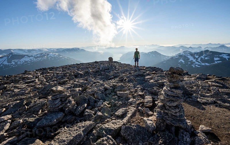 Mountaineer on the summit of Skala with cairn, view of mountain landscape and fjord Faleidfjorden, Sonnenstern, Loen, Norway, Europe