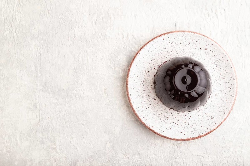 Black currant and grapes jelly on gray concrete background. top view, flat lay, copy space
