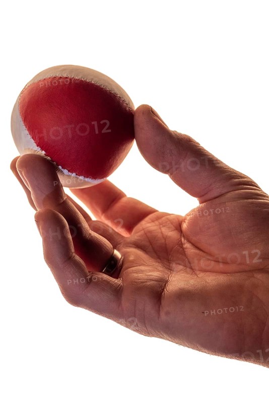 Hand with a juggling ball in front of a white background, studio shot, Germany, Europe