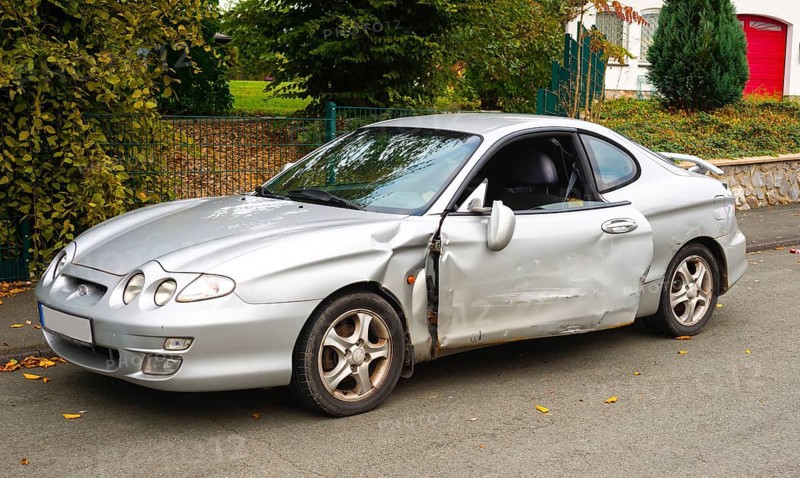 Accident car, sporty car with accident damage standing on a road, silver motor vehicle, car with considerable damage to the side standing on a road, Germany, Europe