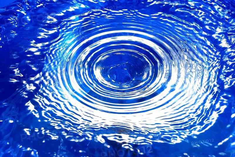 A water vortex in blue water, with concentric circles
