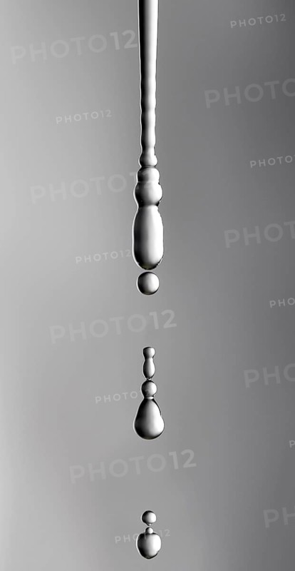 A thin stream of water from a sponge breaks off and begins to drip