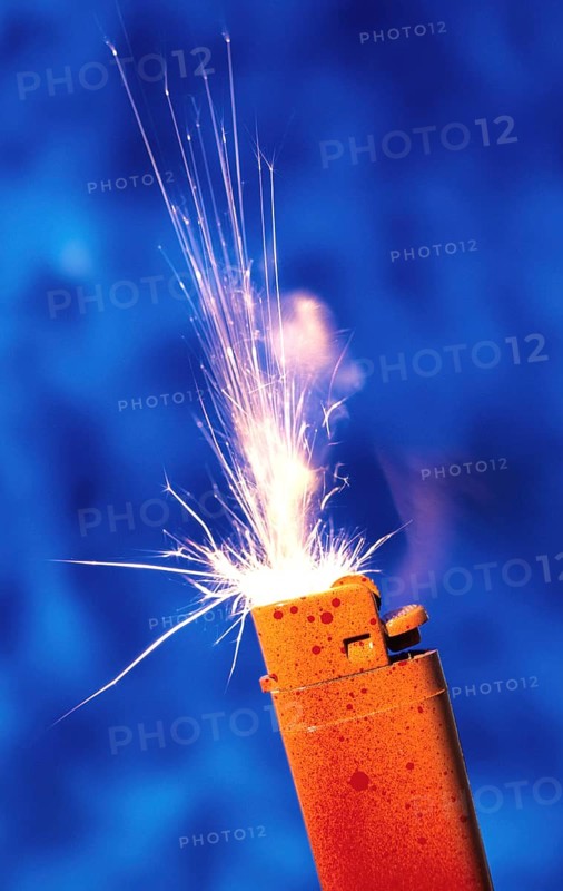 An orange-red lighter sprays sparks against a blue background