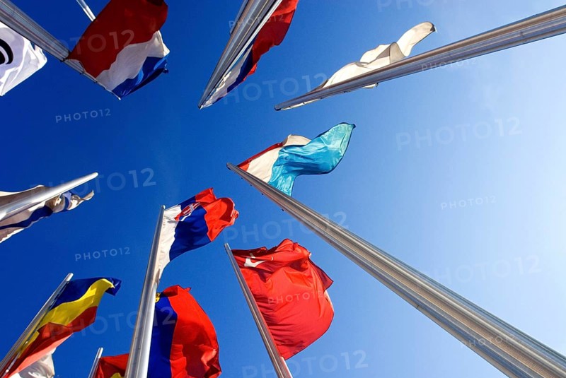 Wide angle shot of European national flags, frog perspective, against blue sky, in front of the European Patent Office in Munich, Bavaria, Germany, Europe