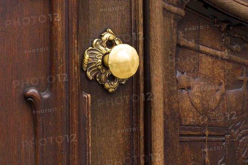 Worn brass doorknob on a dark wooden door of the Asamkirche, Sendlinger Straße, Munich, Bavaria, Germany, Europe