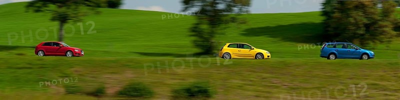 A blue, yellow and red car driving through a green landscape near Bad Kohlgrub, Bavaria, Germany, Europe