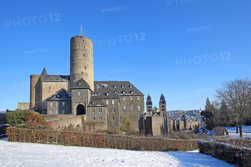 Genoveva Castle built in the 13th century with keep Goloturm and neo-Romanesque Herz-Jesu-Kirche built in 1911 with twin towers in winter with snow, Mayen, Vulkaneifel, Eifel, Rhineland-Palatinate, Germany, Europe