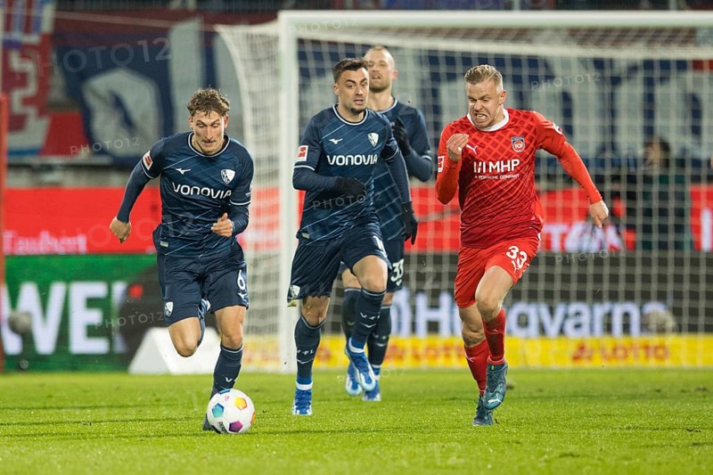 Football match, Lennard MALONEY re.1.FC Heidenheim in a running duel with Patrick OSTERHAGE VFL Bochum, in the centre Philipp Förster VFL Bochum observes the scene, football stadium Voith-Arena, Heidenheim