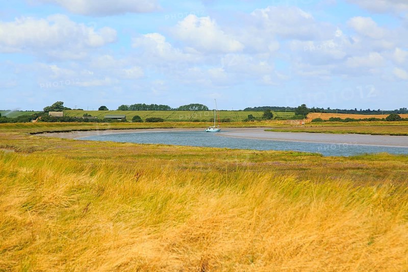 Butley Creek river landscape, Boyton, Suffolk, England, UK with moored yacht