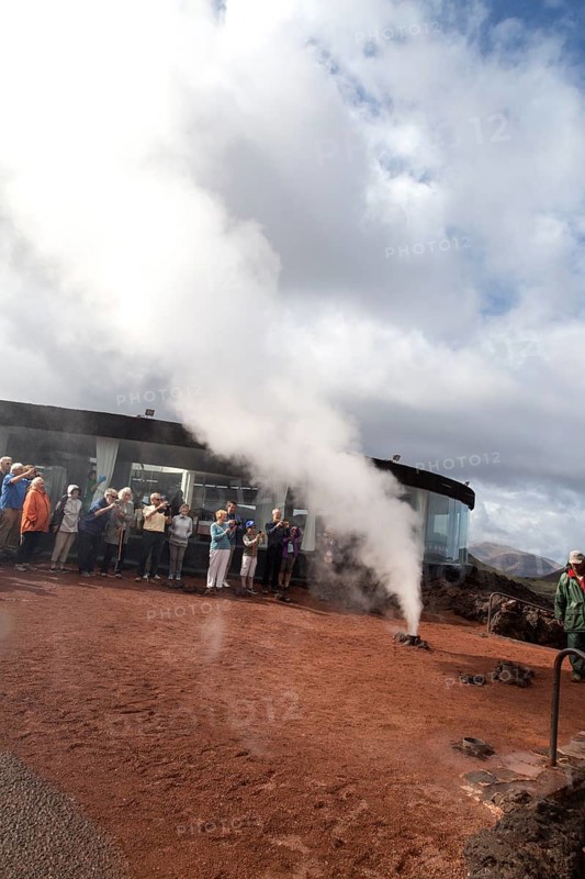 Tourists watch steam rise from geyser spout, Parque Nacional de Timanfaya, national park, Lanzarote, Canary Islands