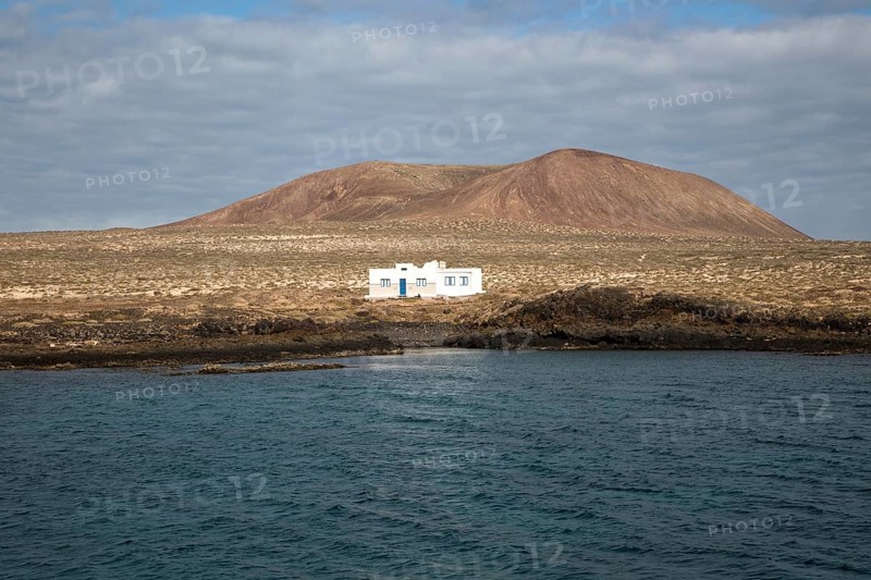 Isolated whitewashed house and Agujas Grandes volcano, La Isla Graciosa, Lanzarote, Canary Islands, Spain, Europe
