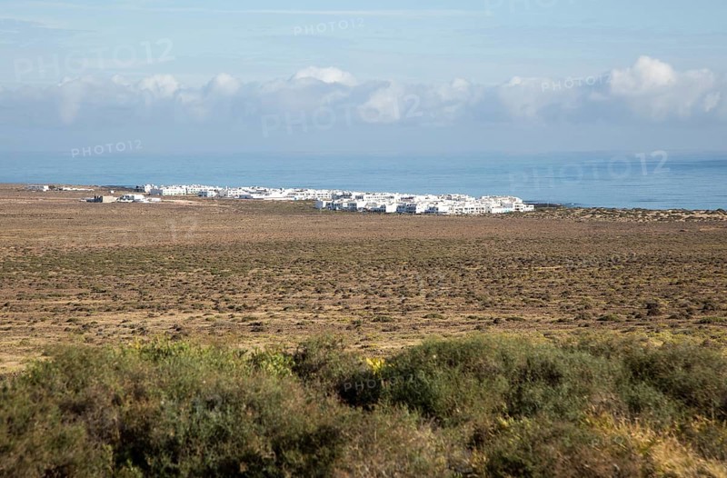 White cuboid buildings of coastal village La Caleta de Famara, Lanzarote, Canary islands, Spain, Europe