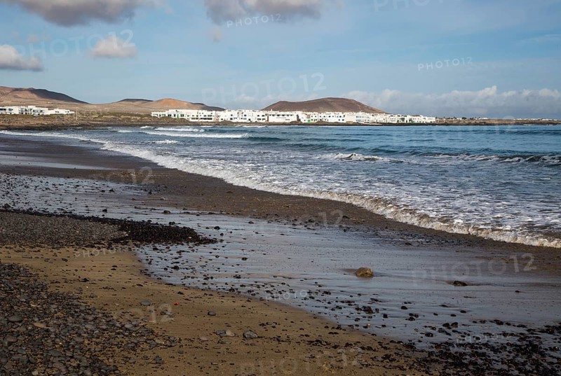 White cuboid buildings of coastal village La Caleta de Famara, Lanzarote, Canary islands, Spain, Europe