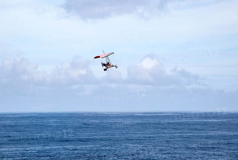 Person flying microlight plane over the ocean, Caleta de Caballo, Lanzarote, Canary islands, Spain, Europe