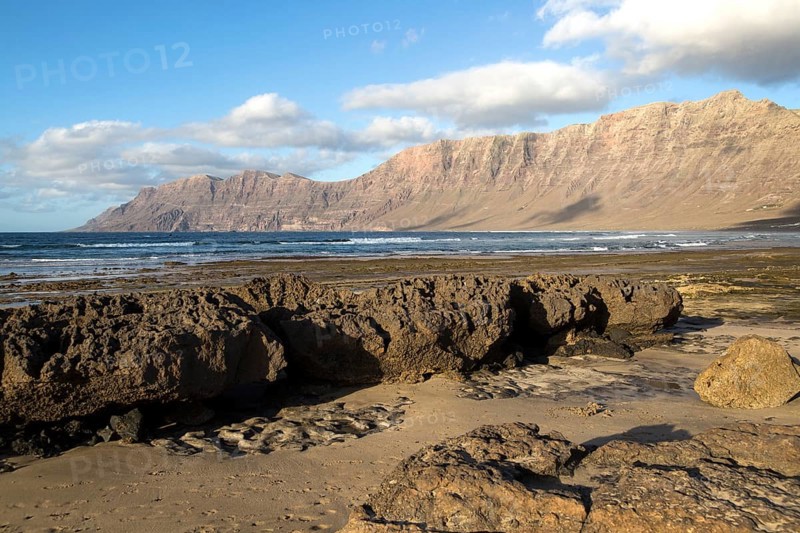Late afternoon light on beach and cliffs La Caleta de Famara, Lanzarote, Canary islands, Spain, Europe