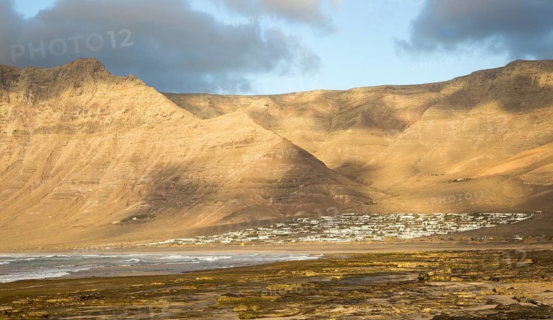 Late afternoon light on beach and cliffs La Caleta de Famara, Lanzarote, Canary islands, Spain, Europe