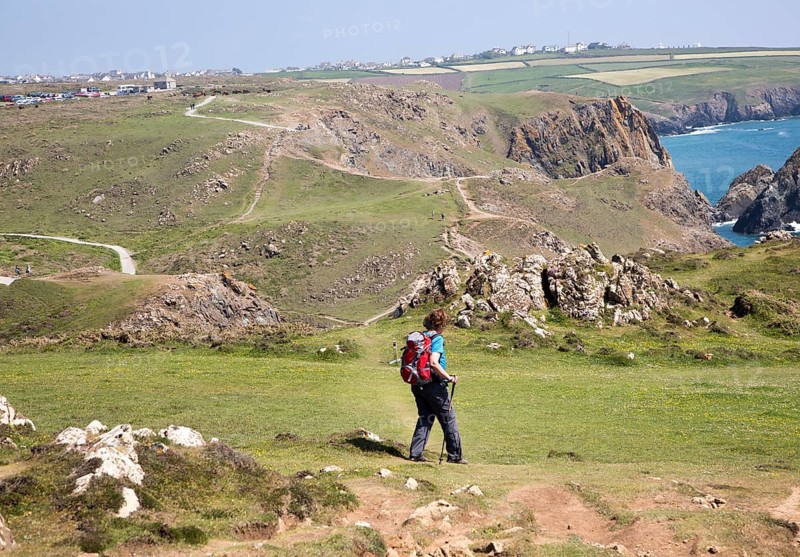 Woman walking near Kynance Cove, Lizard peninsula, Cornwall, England, UK