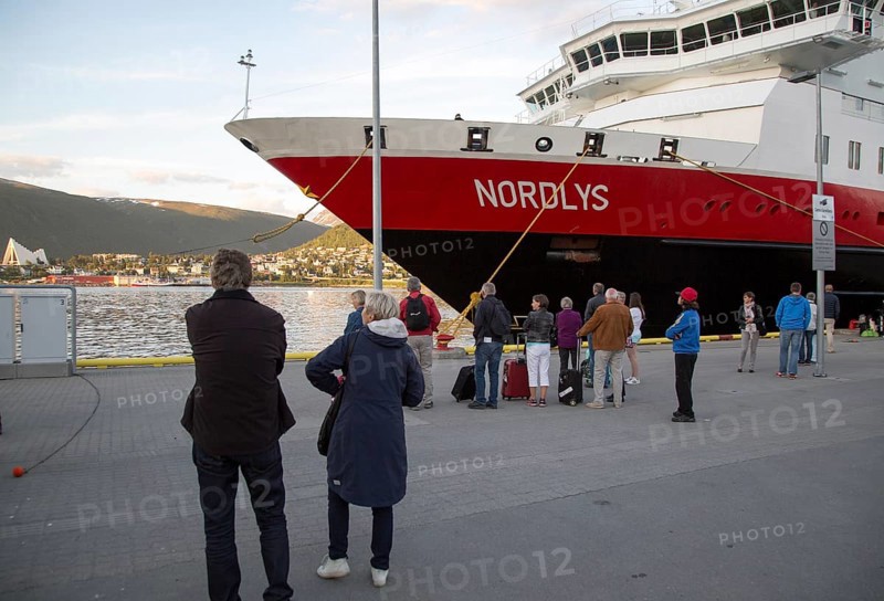 Hurtigruten ferry ship Nordlys with waiting passengers moored at Tromso, Norway, Europe