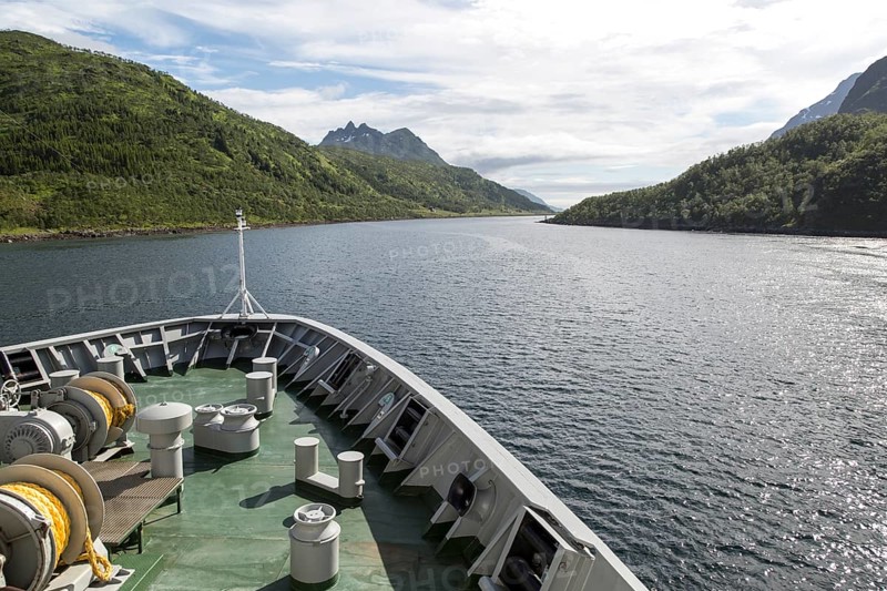 Hurtigruten ferry ship passing down fjord Raftsundet, Hinnoya Island, Nordland, northern Norway