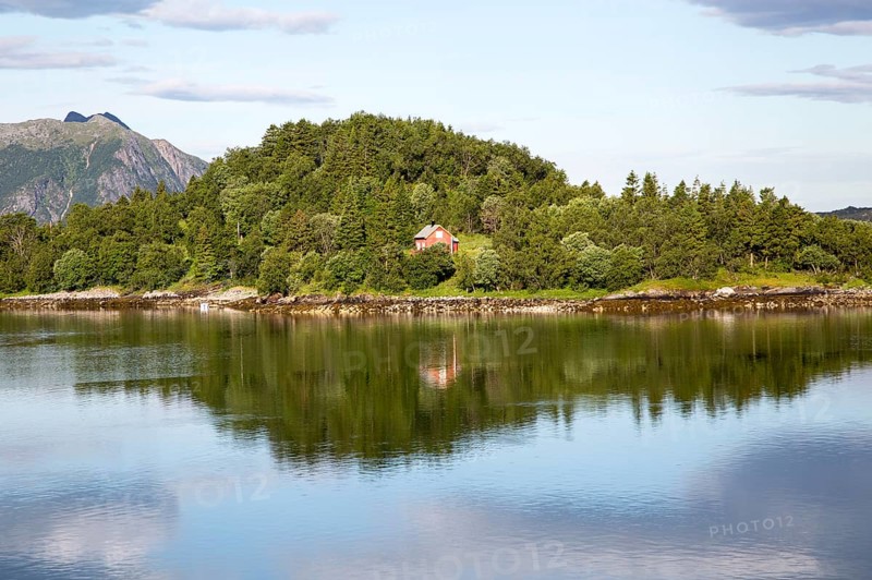 Isolated coastal house on small wooded island near Ornes, Nordland, Norway, Europe