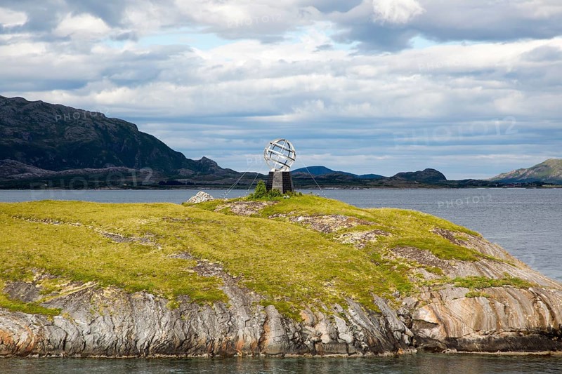 Monument marker to show crossing the Arctic Circle heading south on small island, Norway, Europe