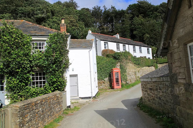 Traditional red telephone box and whitewashed corsages, village of Durgan, Cornwall, England, UK