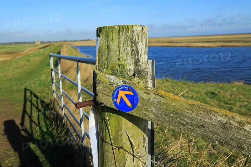 Suffolk Coast path sign along flood defence wall, near Shingle Street, Suffolk, England, UK