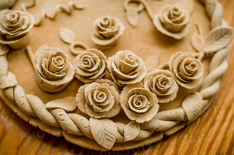 Image of a pastel beige dough sculpture with rose patterns, Teig, gebacken