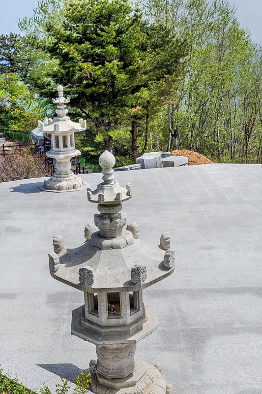 Stone carved lanterns on concrete plaza in park in Goseong, South Korea, Asia
