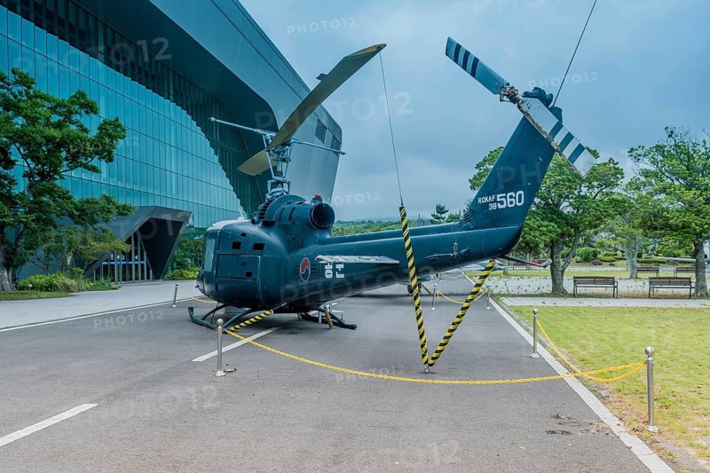 Bell UH-1B helicopter on pavement at museum under cloudy sky in Jeju, South Korea, Asia