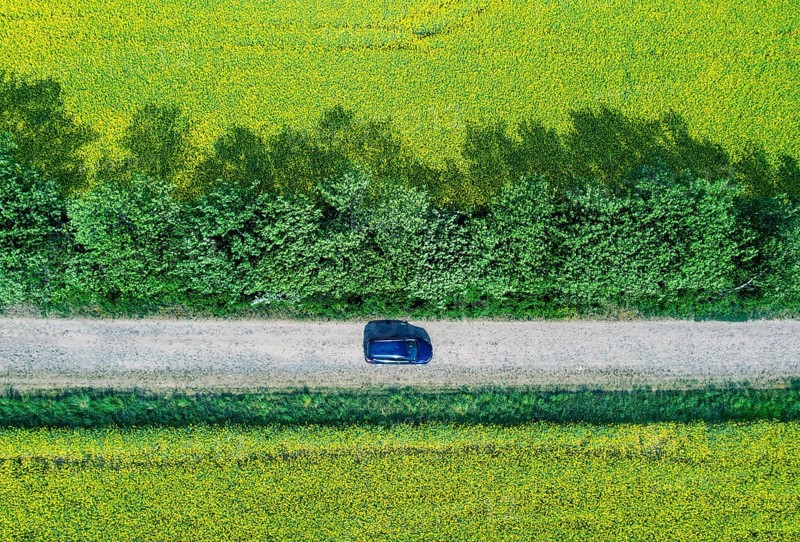 Aerial view of a car on a road in rape fields, Kremmen, 20/05/2022