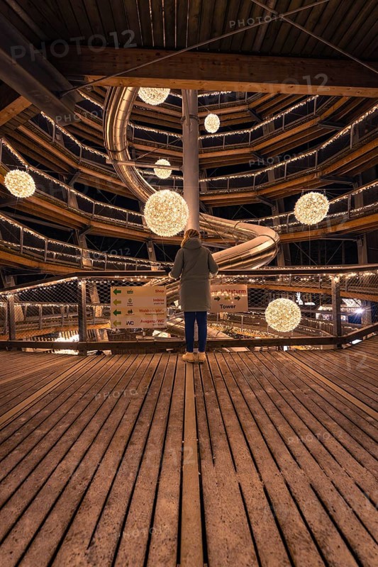 A person looks out onto a spiral-shaped, illuminated viewing platform, Enchanting forest dwellers, Bad Wildbad treetop walk, Black Forest, Germany, Europe