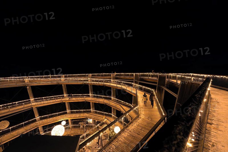 Night shot of an illuminated wooden bridge with people, enchanting forest dwellers, treetop walk Bad Wildbad, Black Forest, Germany, Europe