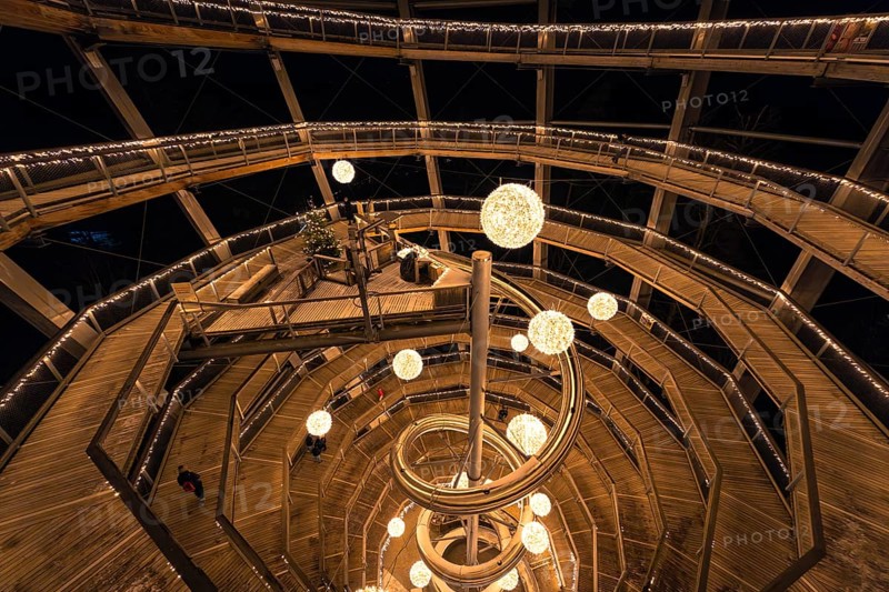 People walk through a spiral-shaped wooden construction with lights at night, magical forest dwellers, treetop walk Bad Wildbad, Black Forest, Germany, Europe