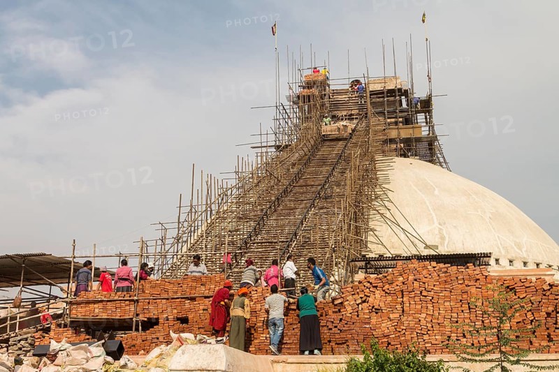 Reconstruction works in progress at Boudhanath, the Bouddha Stupa, one of the UNESCO World Heritage Sites in the Kathmandu Valley. The stupa, which is an important Buddhist religious site, has been severely damaged during the April 2015 Nepal earthquake, the Gorkha earthquake, and was very quickly rebuilt thanks to the efforts of the local community and donors from various corners of the World. Photographed in April 2016, a year after the earthquake. Kathmandu, Bagmati Province, Nepal, Asia