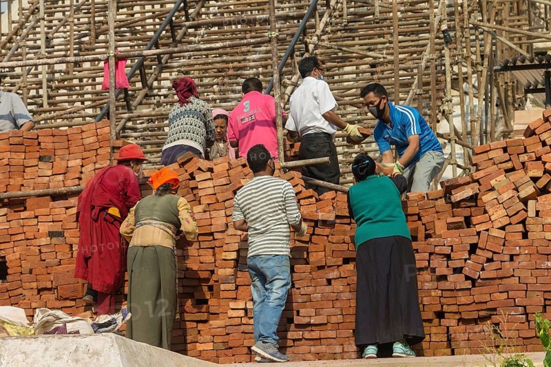 Reconstruction works in progress at Boudhanath, the Bouddha Stupa, one of the UNESCO World Heritage Sites in the Kathmandu Valley. The stupa, which is an important Buddhist religious site, has been severely damaged during the April 2015 Nepal earthquake, the Gorkha earthquake, and was very quickly rebuilt thanks to the efforts of the local community and donors from various corners of the World. Photographed in April 2016, a year after the earthquake. Kathmandu, Bagmati Province, Nepal, Asia