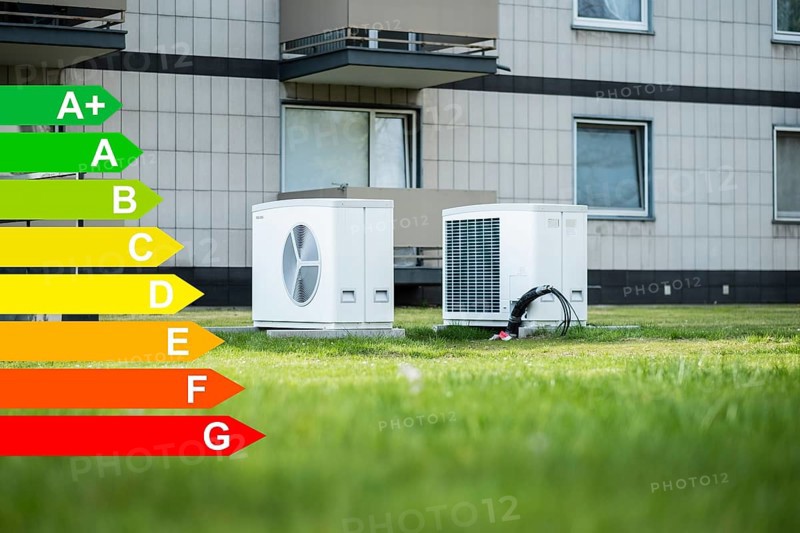 Two heat pumps on a lawn of a family home, graphic with energy efficiency classes for buildings according to the GEG, Düsseldorf, Germany, Europe