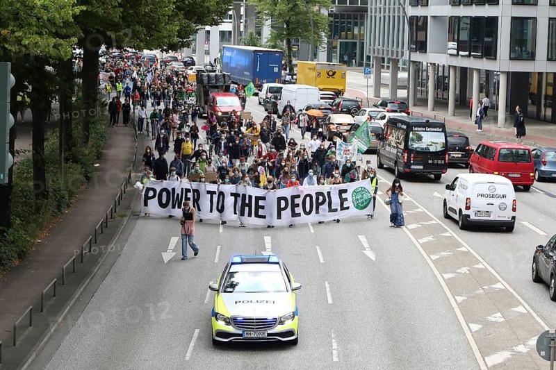 Police car and demonstrators behind banner with the inscription Power to the people at the alliance demo on climate racism and climate flight, with Fridays For Future, Extinction Rebellion, Sea-Watch, Sea-Eye, Seebrücke, Omas gegen Rechts in Hamburg, Germany, among others, Europe