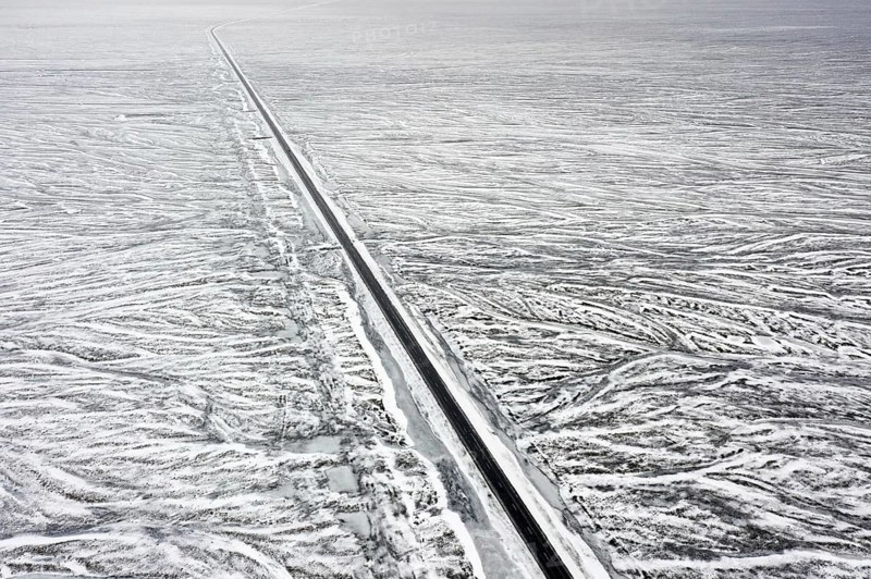 Aerial view over Route 1, Ring Road, two-lane national road in desolate snow covered winter landscape, Suðurland, Southern Region, South Iceland