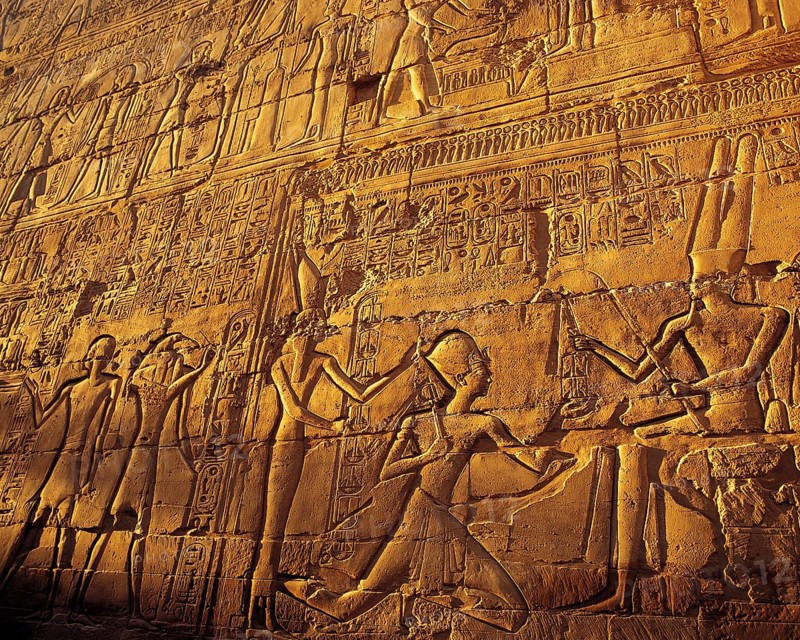 Elaborate carved stone relief with close-ups of pharonic figures in strong evening side-light, at Karnak temple, Luxor, Egypt, Africa