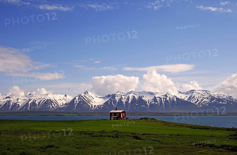 Wooden cabin on the shores of Eyjafjordur with the Kaldbakur mountains behind, near Dalvik, north-central Iceland