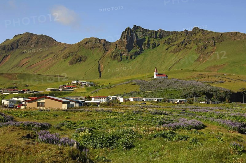 The town of Vik, southern Iceland, with its church above, all beneath crags and steep hillsides