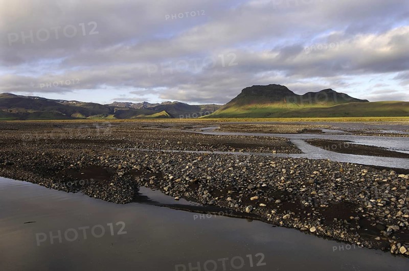 Evening light on the braids of the Syslalaekur river, with dappled light on distant hills, southern Iceland